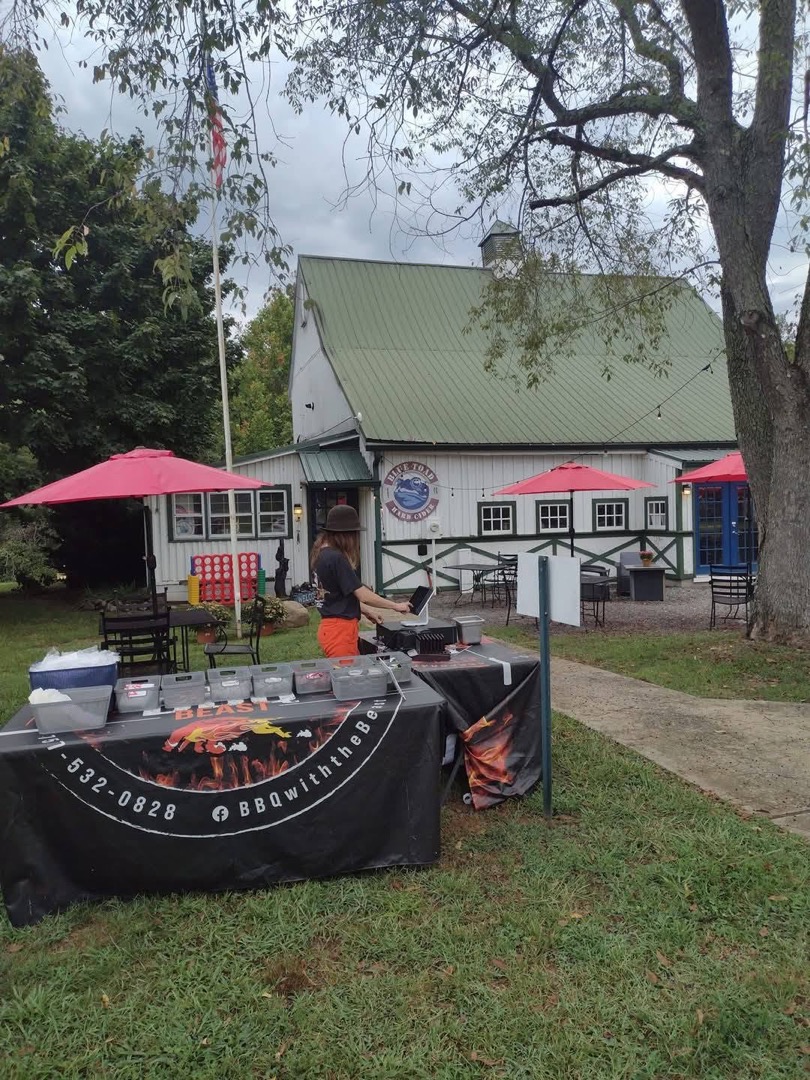 A catering table dressed in the crew's branded black throw, set up at an outdoor venue