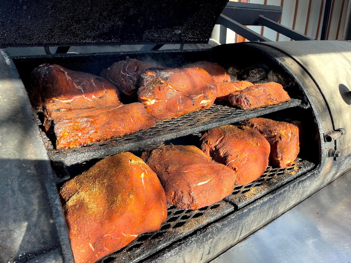 Meat on the rig's barrel grates, mid-smoke