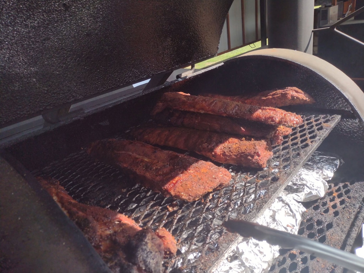 Rib racks laid across the rig's barrel grates over the coals
